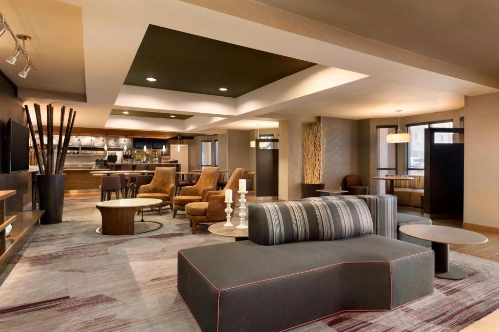 a lobby of a hotel with a couch and tables at Courtyard by Marriott Bloomington Normal in Bloomington