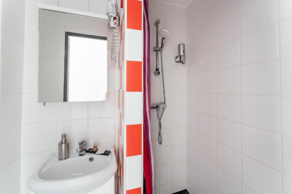 a bathroom with a sink and a mirror at L&#39;Oasis Montparnasse in Paris