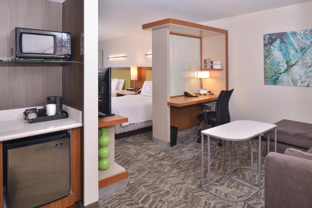 a hotel room with a bed and a desk at SpringHill Suites Las Vegas Henderson in Las Vegas