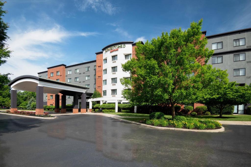 un hotel con aparcamiento frente a un edificio en Courtyard Philadelphia Valley Forge Collegeville, en Collegeville