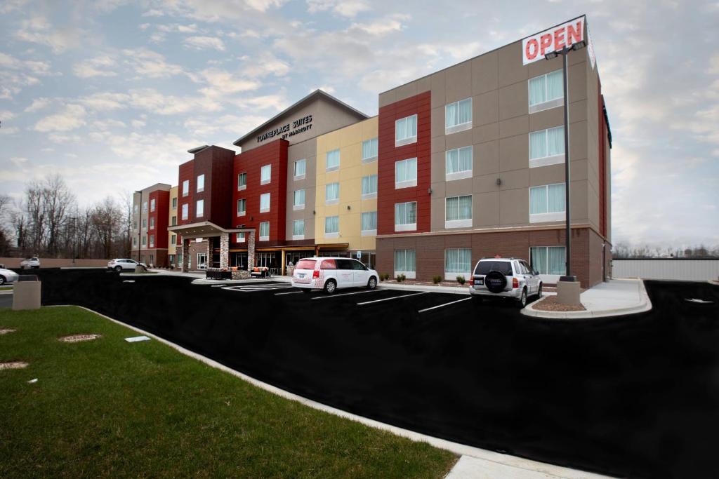 un hotel con coches estacionados en un estacionamiento en TownePlace Suites by Marriott Louisville Airport en Louisville