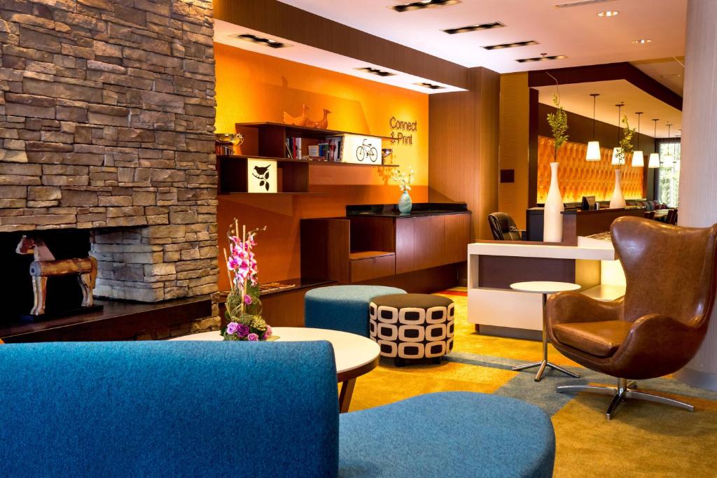 a lobby with blue chairs and a fireplace at Fairfield Inn & Suites by Marriott Richmond Midlothian in Richmond