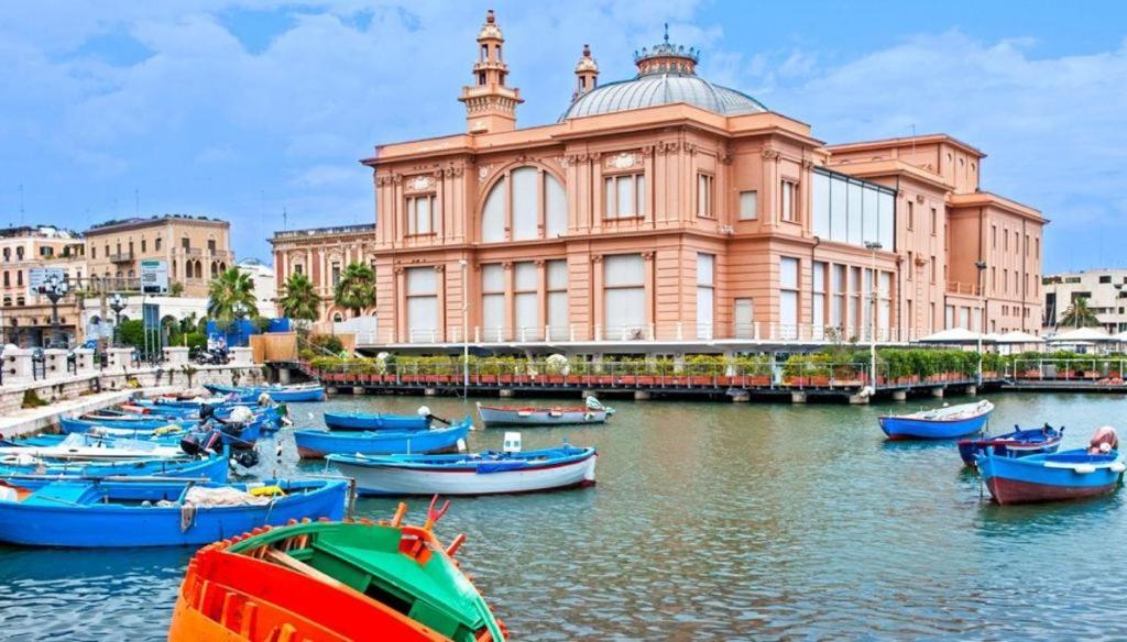 un gruppo di barche in acqua di fronte a un edificio di Ely's Home a Bari