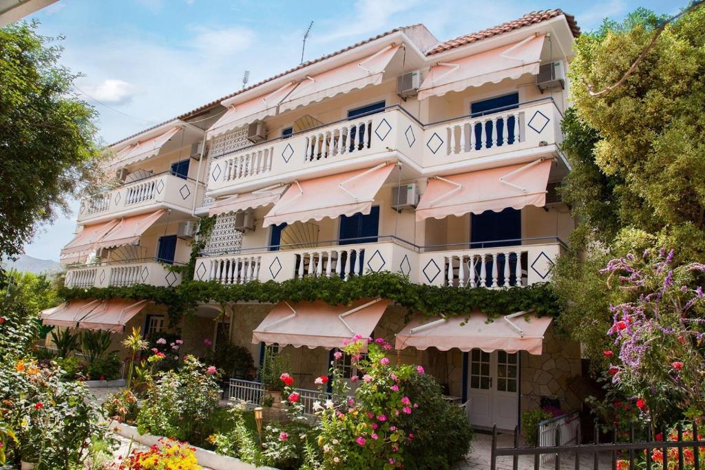 um edifício com varandas e flores em frente em Borsalino Studios em Nydri