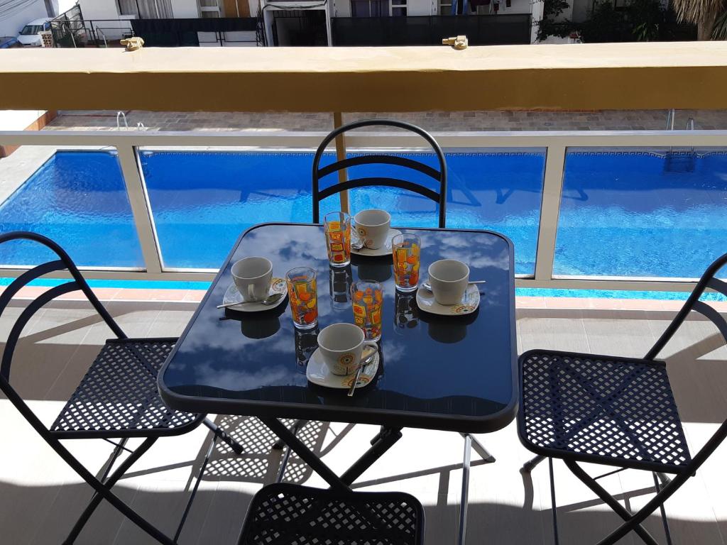 een blauwe tafel en stoelen met bekers en drankjes erop bij NEW Palacio del Sol Torremolinos in Torremolinos