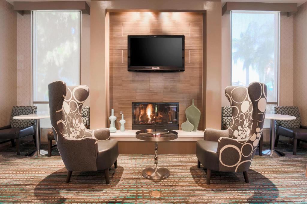 a living room with two chairs and a fireplace at Residence Inn Bakersfield in Bakersfield