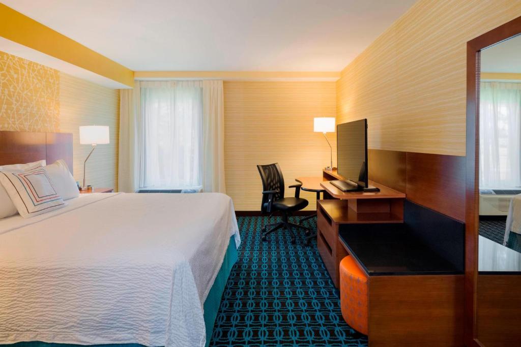 a hotel room with a bed and a desk and a television at Fairfield Inn & Suites by Marriott Paramus in Paramus