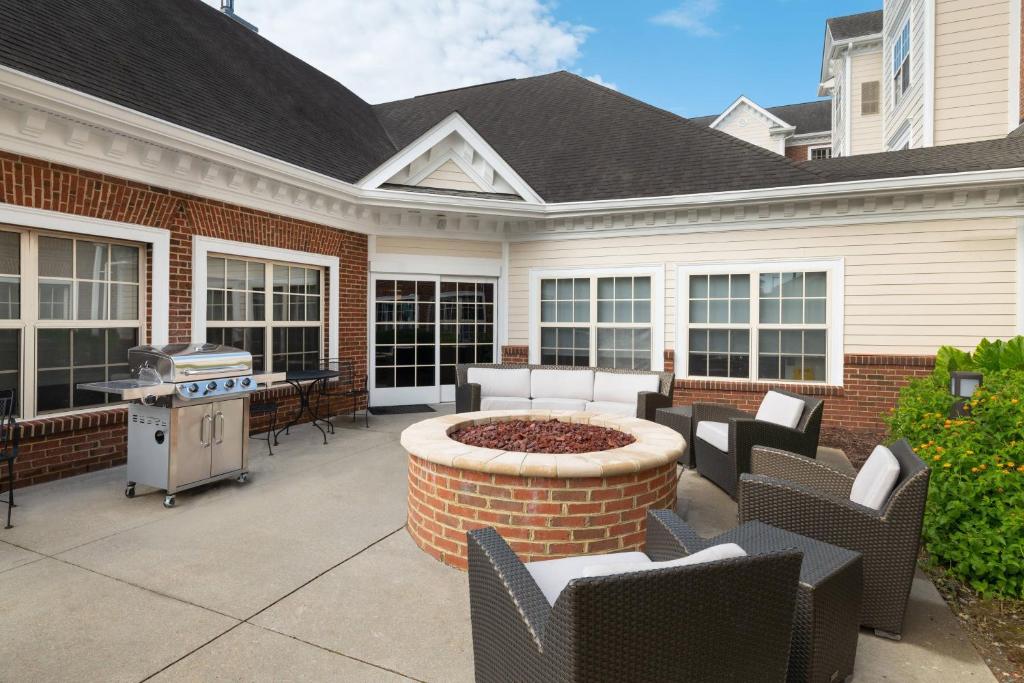 a patio with chairs and a fire pit in front of a house at Residence Inn by Marriott Williamsburg in Williamsburg