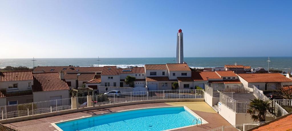 a view of a swimming pool on a building with the ocean at Maisonnette du Sémaphore - Jardin, piscine & parking à La Chaume in Les Sables-d'Olonne