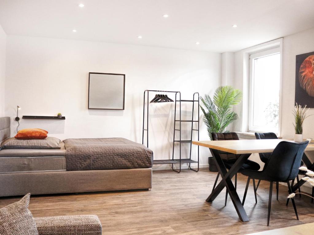 een slaapkamer met een bed en een tafel en stoelen bij LIGHTPLACE • Größere Gruppen • 4 Einzelzimmer • Boxspring • Smart TV • Biergarten • Restaurant in Braunschweig