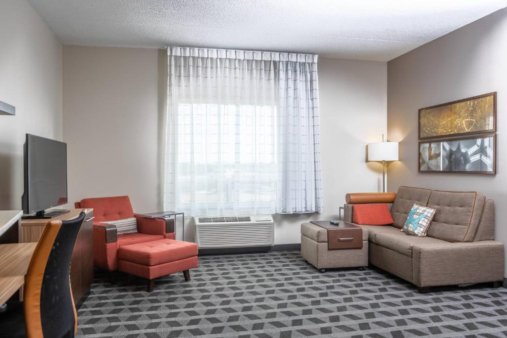 a living room with a couch and chairs and a window at TownePlace Suites by Marriott Petawawa in Petawawa