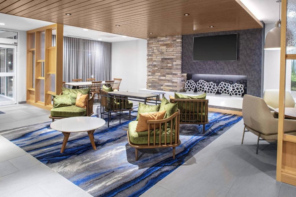 een lobby met stoelen en een tafel en een tv bij Fairfield Inn & Suites by Marriott Indianapolis Greenfield in Greenfield