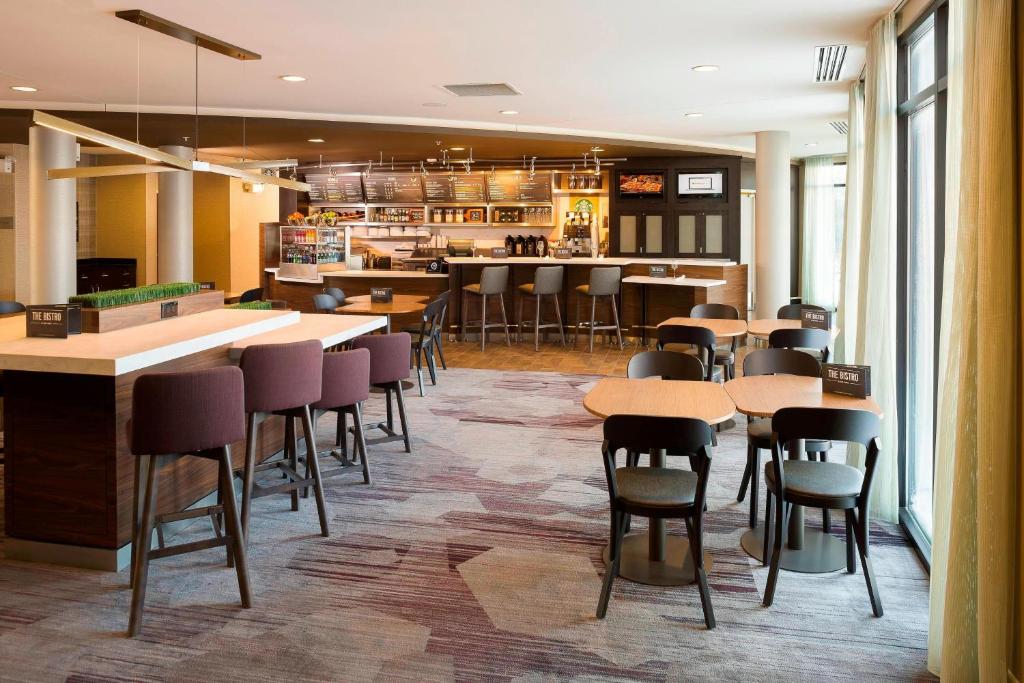 a restaurant with tables and chairs and a bar at Courtyard By Marriott Sioux Falls in Sioux Falls