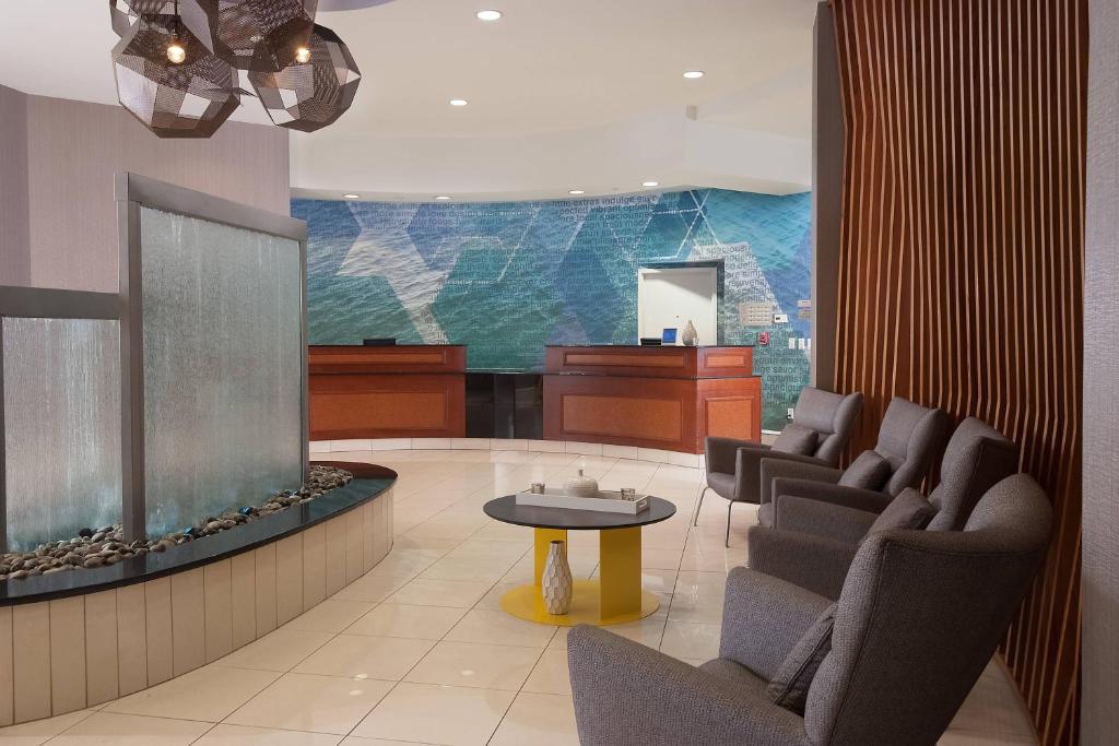 SpringHill Suites Orlando Airport في أورلاندو: غرفة انتظار مع كراسي وحوض أسماك