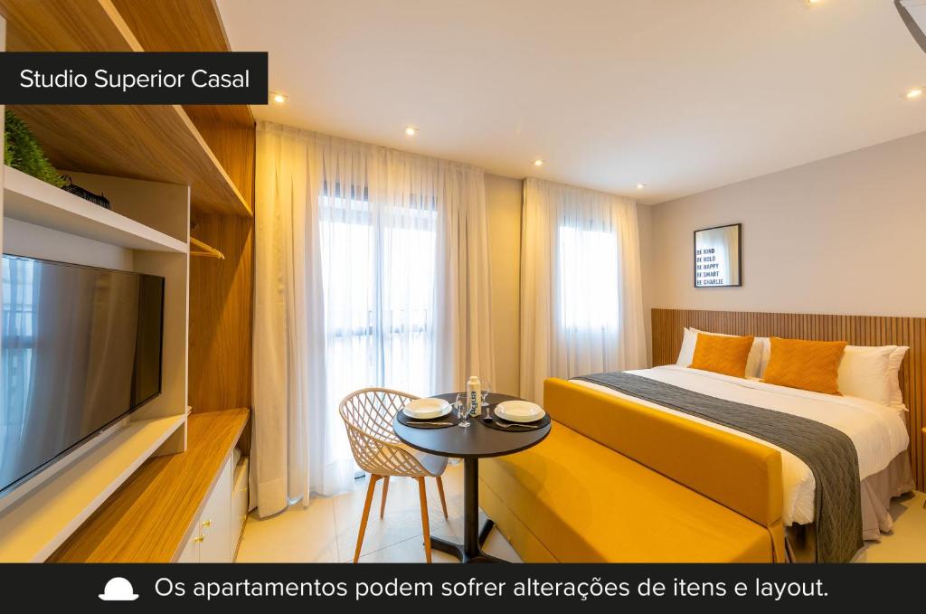 a hotel room with a bed and a table and a tv at Smart Charlie Vitta Campo Belo in Sao Paulo