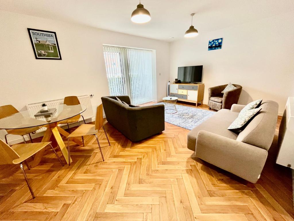 ポーツマスにある2 Double beds OR 4 Singles, 2 Bathrooms, FREE PARKING, Smart TV's, Close to Gunwharf Quays, Beach & Historic Dockyardのリビングルーム(ソファ、テーブル付)