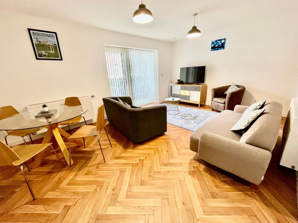 a living room with a couch and a table at 2 Double beds OR 4 Singles, 2 Bathrooms, FREE PARKING, Smart TV's, Close to Gunwharf Quays, Beach & Historic Dockyard in Portsmouth