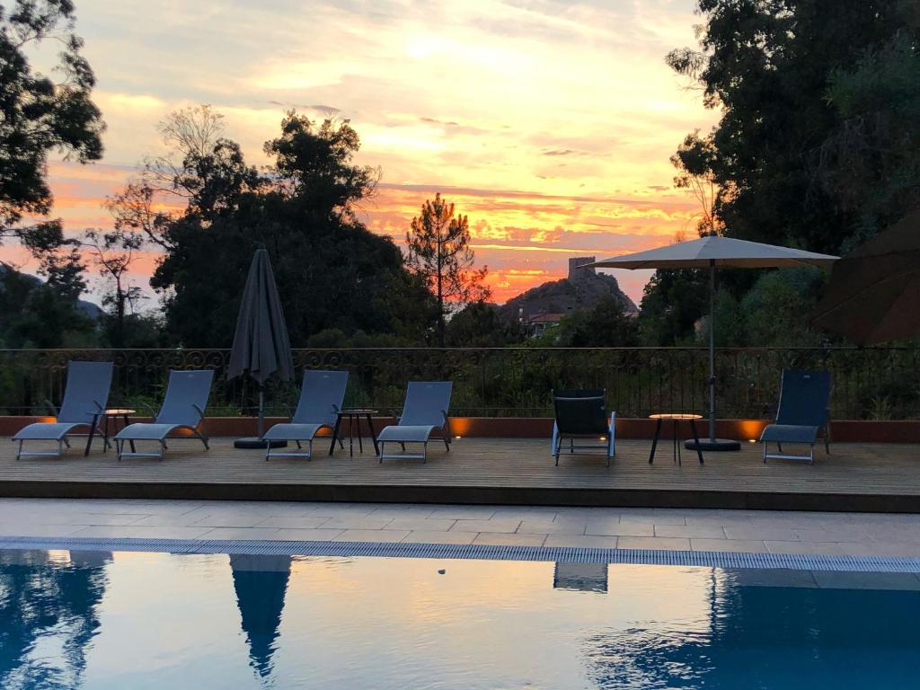 a group of chairs and tables next to a swimming pool at Hotel Corsica - Porto Corse in Porto Ota