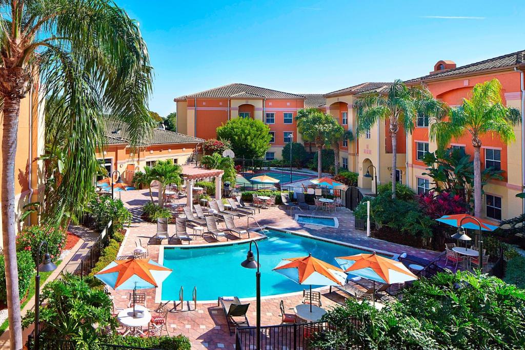 an aerial view of a resort pool with umbrellas at Residence Inn by Marriott Naples in Naples