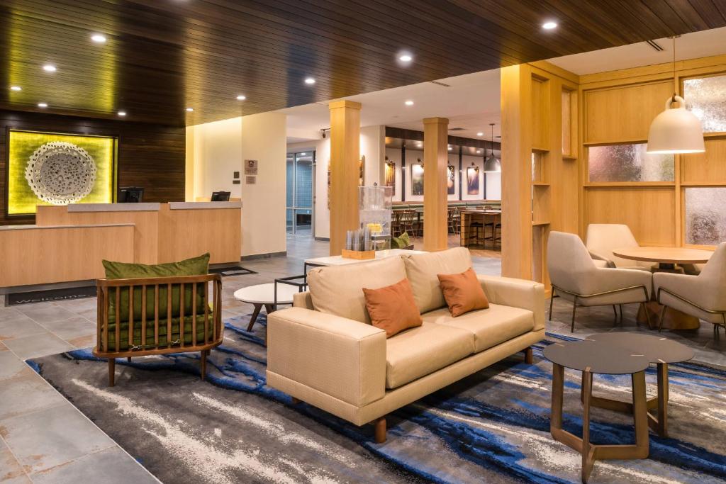 een lobby met een bank, stoelen en tafels bij Fairfield Inn & Suites by Marriott Fort Worth Southwest at Cityview in Fort Worth