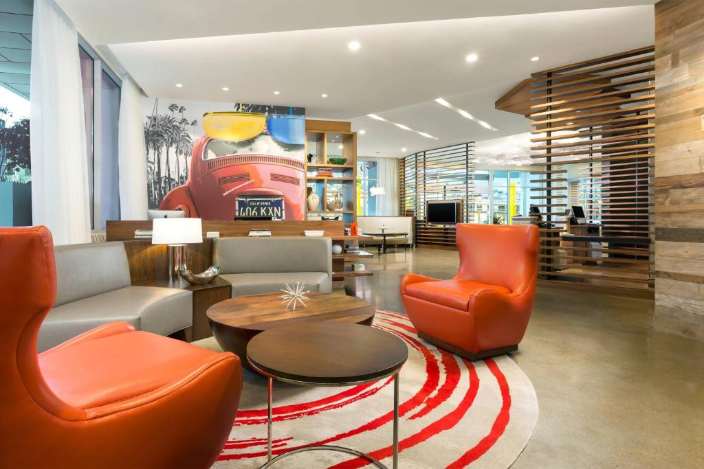 a lobby with orange chairs and a table at Courtyard by Marriott Santa Monica in Los Angeles