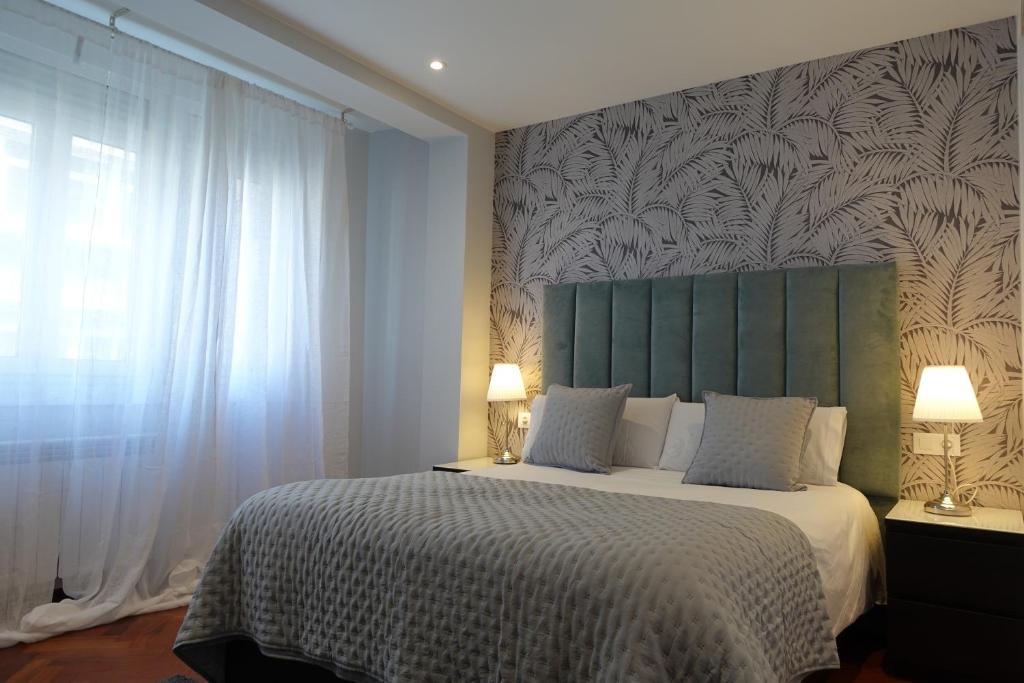 1 dormitorio con 1 cama con cabecero verde y ventana en Céntrico y acogedor piso con garaje, en A Coruña