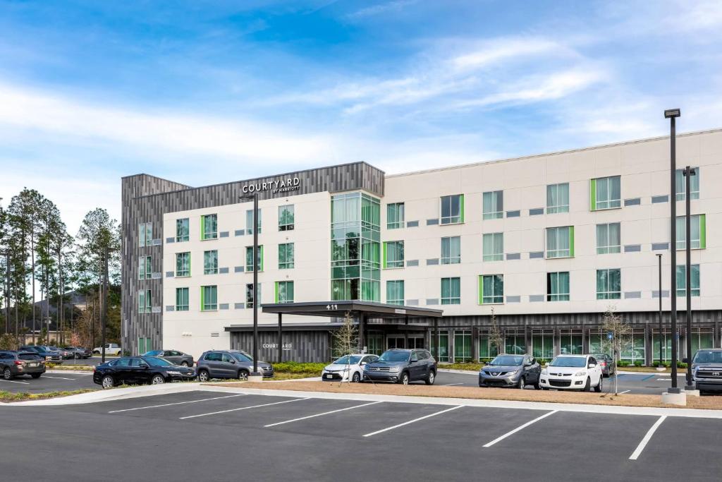 un edificio de oficinas con coches estacionados en un estacionamiento en Courtyard by Marriott Savannah Airport, en Savannah