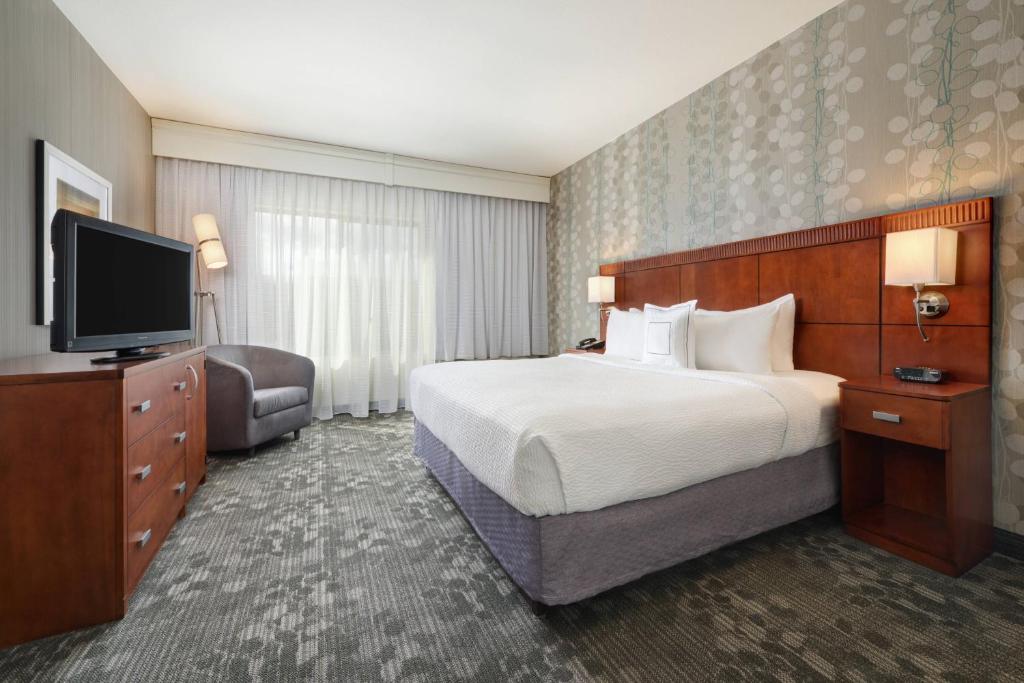 een hotelkamer met een bed en een flatscreen-tv bij Courtyard Grand Junction in Grand Junction