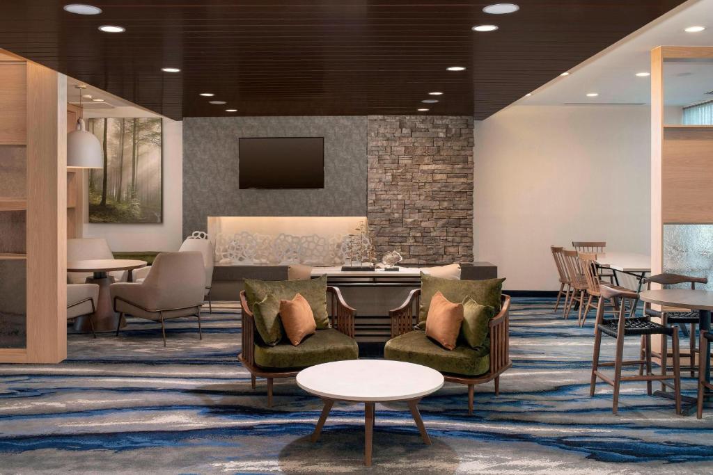 a lobby with chairs and tables and a tv at Fairfield Inn & Suites by Marriott Miami Airport West/Doral in Miami