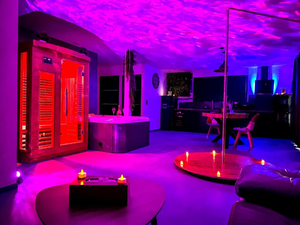 salon z różowym oświetleniem i kuchnią w obiekcie love room Villa Des Charmes-34450 vias w mieście Vias