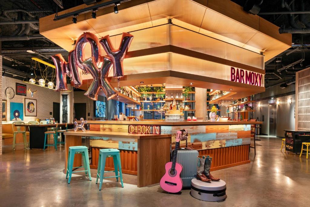 a restaurant with a bar with two guitars and two stools at Moxy Austin - University in Austin