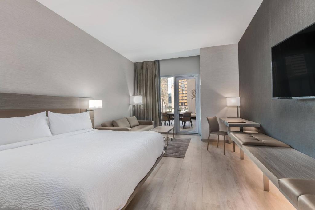 Cette chambre comprend un lit et une télévision. dans l'établissement AC Hotel by Marriott Charlotte City Center, à Charlotte