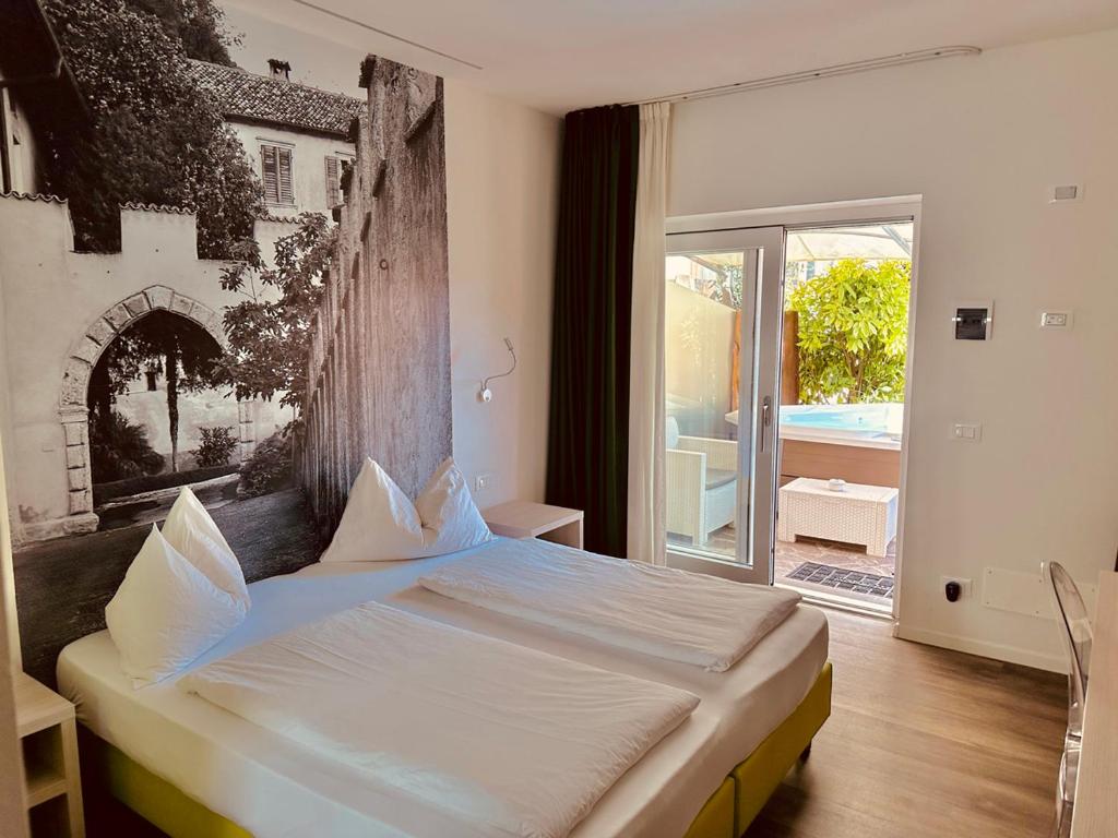 a bedroom with a bed and a large window at CASA da CARMEN - Relax & Tradizione in Mezzolombardo