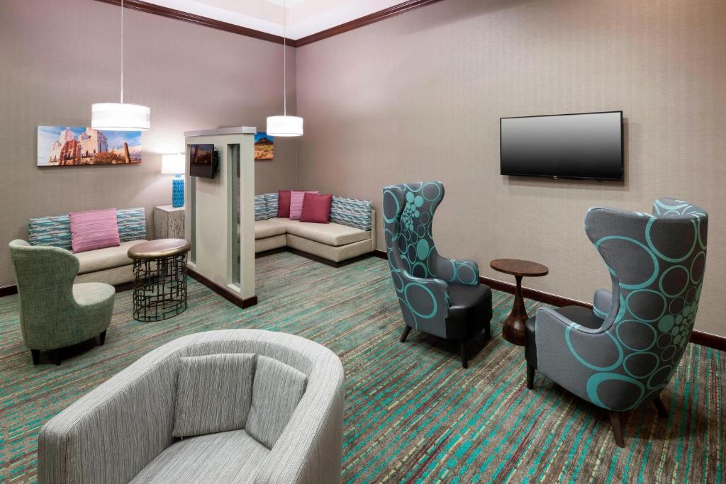 a living room with a couch and chairs and a tv at Residence Inn Tucson Airport in Tucson