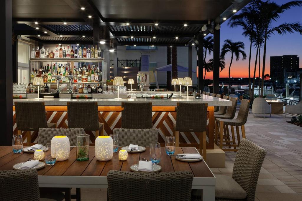 a restaurant with a wooden table and a bar at Tampa Marriott Water Street in Tampa