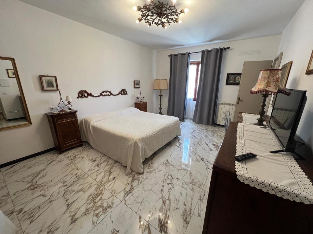 a bedroom with a bed and a table and a television at Le Camere dei Magi in Saturnia