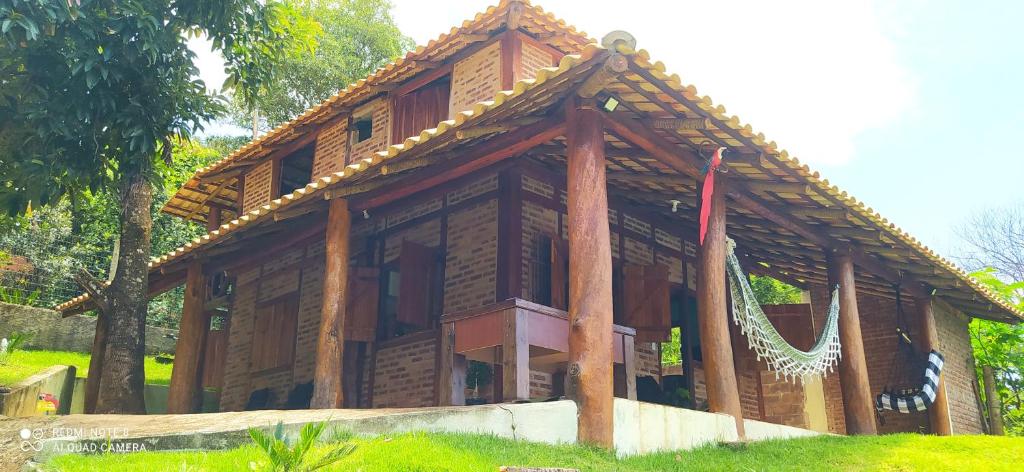 een groot houten huis met een dak bij Sitio meu Sonho in Itatiayassú