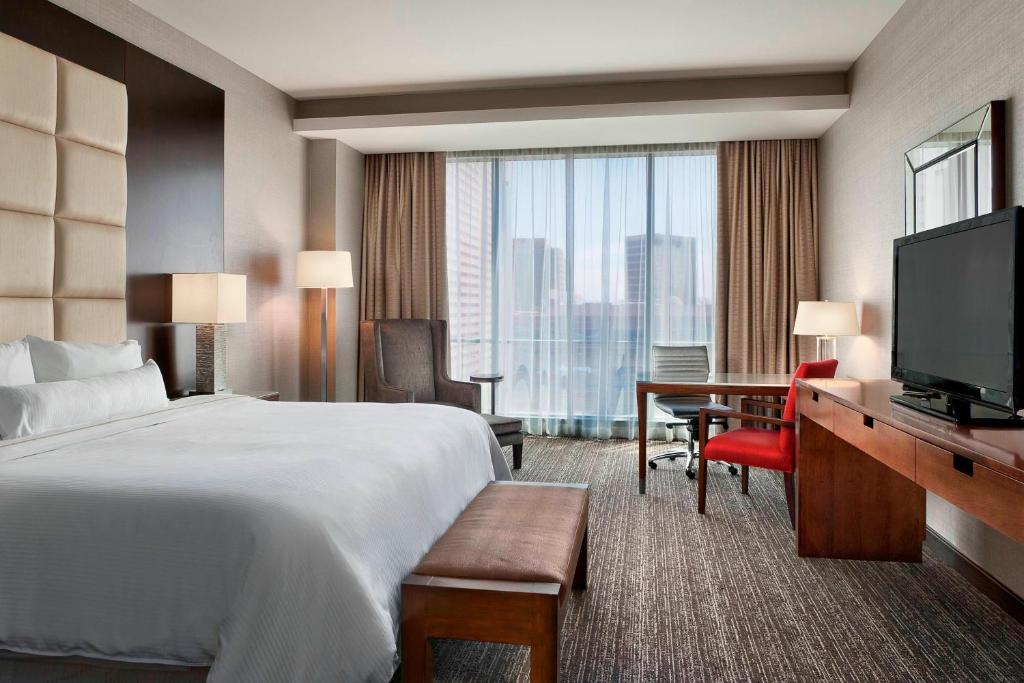 a hotel room with a bed and a desk and a television at The Westin Phoenix Downtown in Phoenix