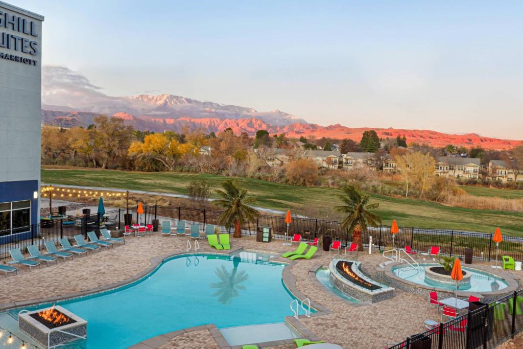 a pool at a resort with mountains in the background at SpringHill Suites by Marriott St. George Washington in Washington