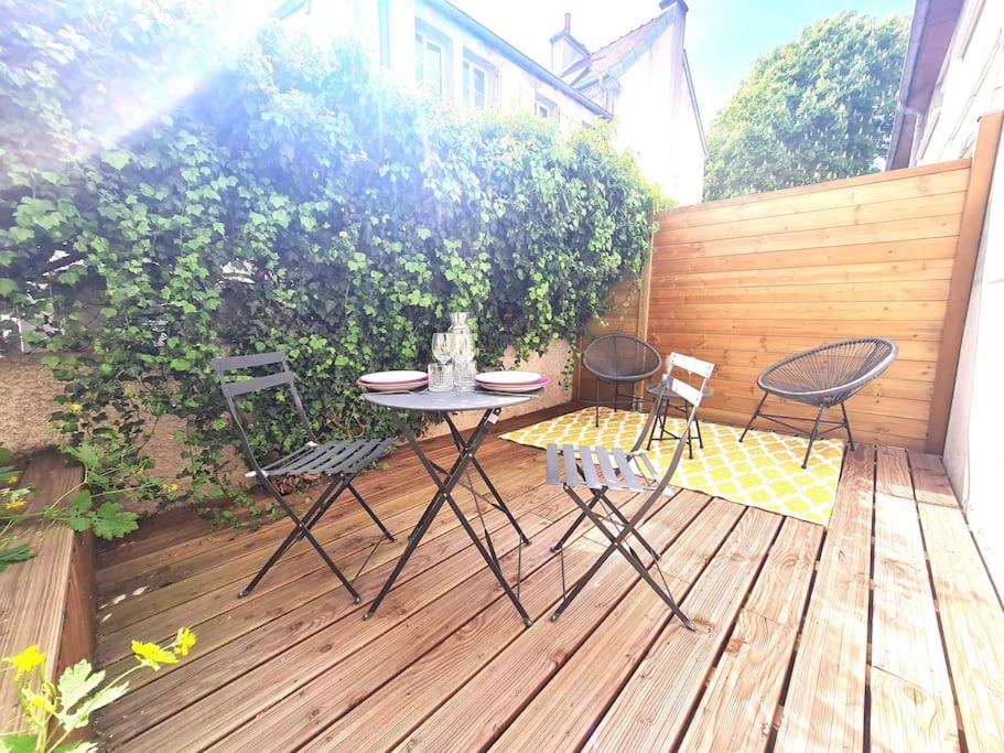 une terrasse en bois avec une table et des chaises. dans l'établissement Le Lemon : au coeur du centre historique, à Dijon