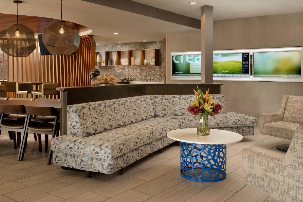 SpringHill Suites Dallas Arlington North في أرلينغتون: غرفة معيشة مع أريكة وطاولة