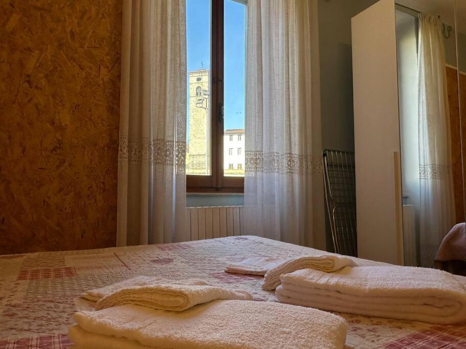 1 dormitorio con 1 cama con 2 toallas en Dimitri's House! view of the Cathedral en Castelnuovo di Garfagnana