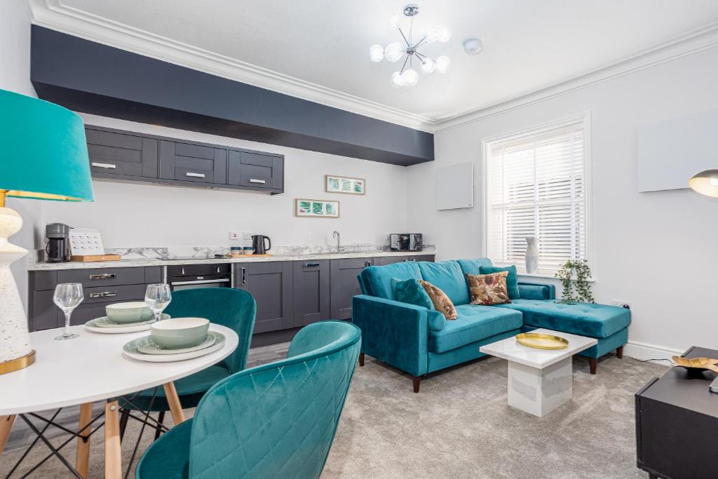 ein Wohnzimmer mit einem blauen Sofa und einem Tisch in der Unterkunft Coppergate Mews Grimsby No7 - 2 bed, 2 bath, 1st floor apartment in Grimsby