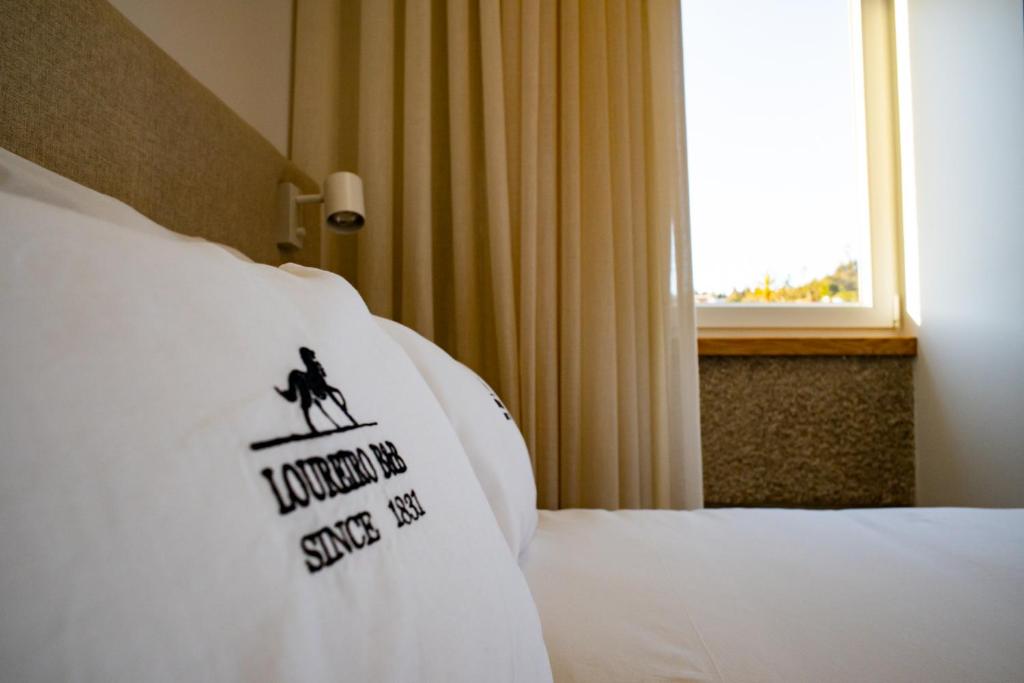 a hotel room with a pillow with a sign on it at Loureiro B&B in São Pedro do Sul