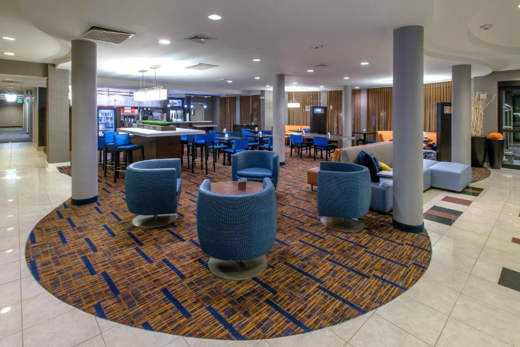 a lobby with tables and chairs on a rug at Courtyard by Marriott Albany in Albany