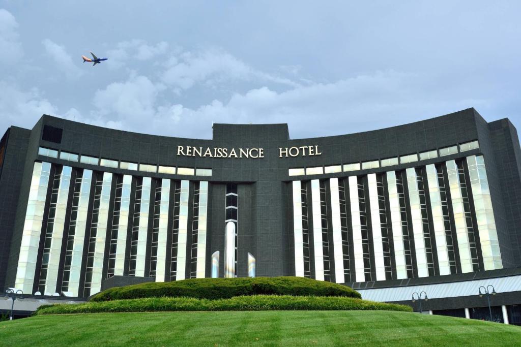 um grande edifício com um avião voando no céu em Renaissance St. Louis Airport Hotel em Saint Louis
