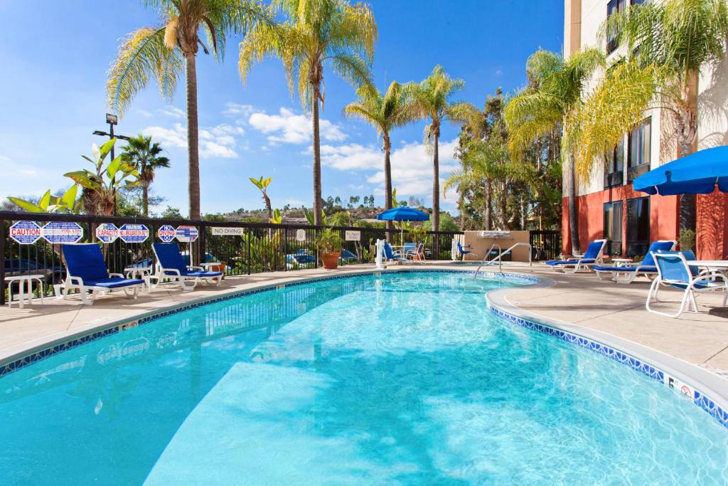 a large swimming pool with chairs and palm trees at Fairfield Mission Viejo Orange County in Mission Viejo