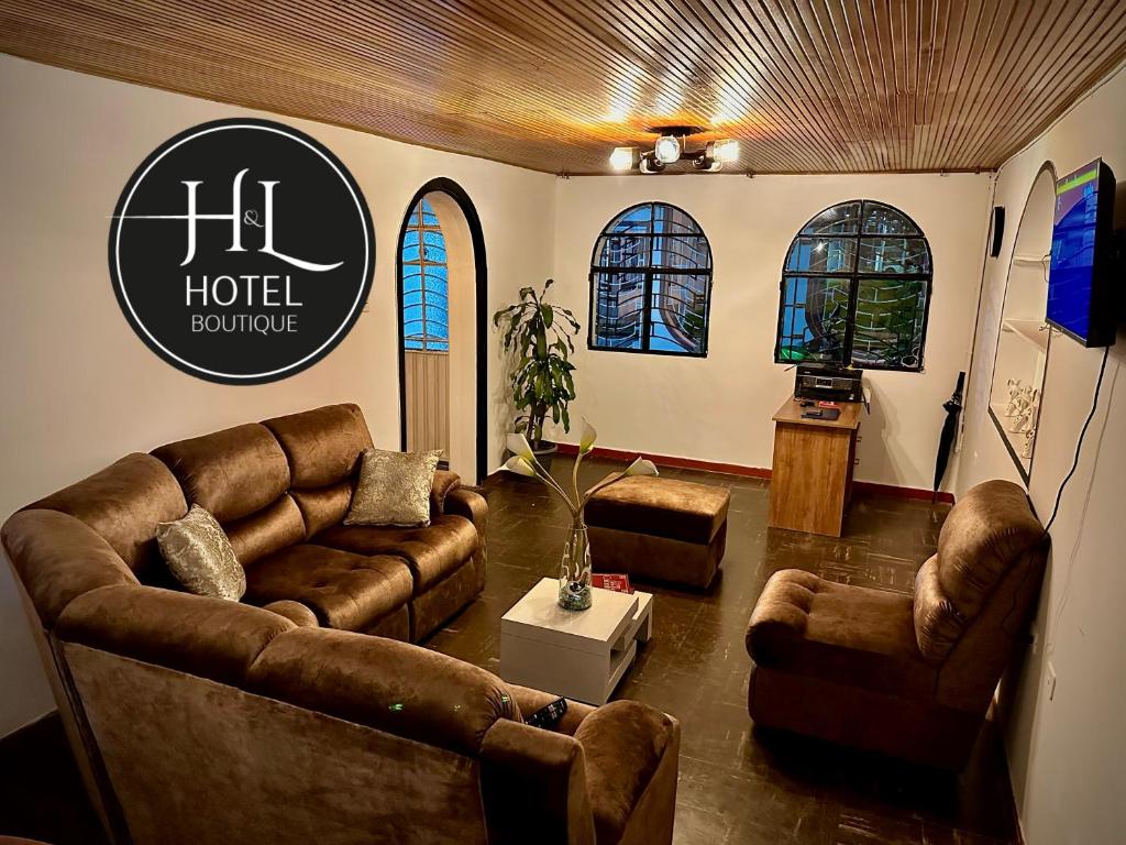 soggiorno con divani in pelle e cartello rimbalzante dell'hotel di H&L BOUTIQUE a Bogotá