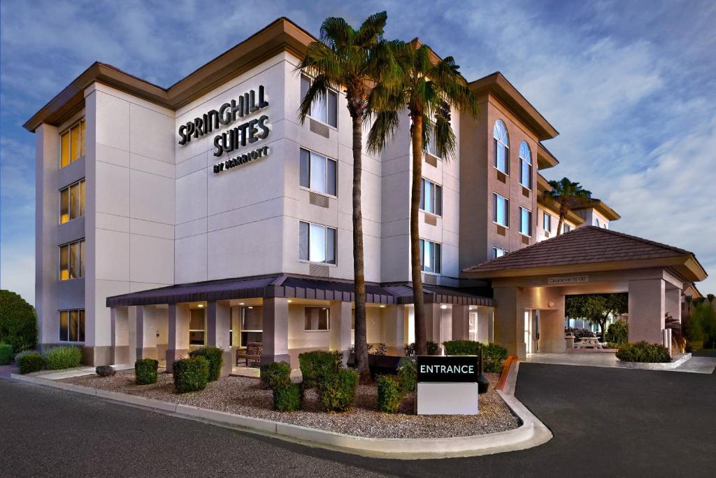 a hotel with a palm tree in front of a building at SpringHill Suites Phoenix Glendale/Peoria in Peoria