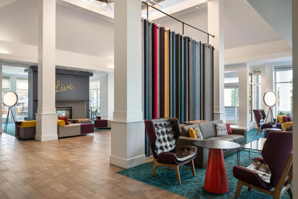 a lobby with chairs and tables and a fireplace at Aloft Mountain View in Mountain View